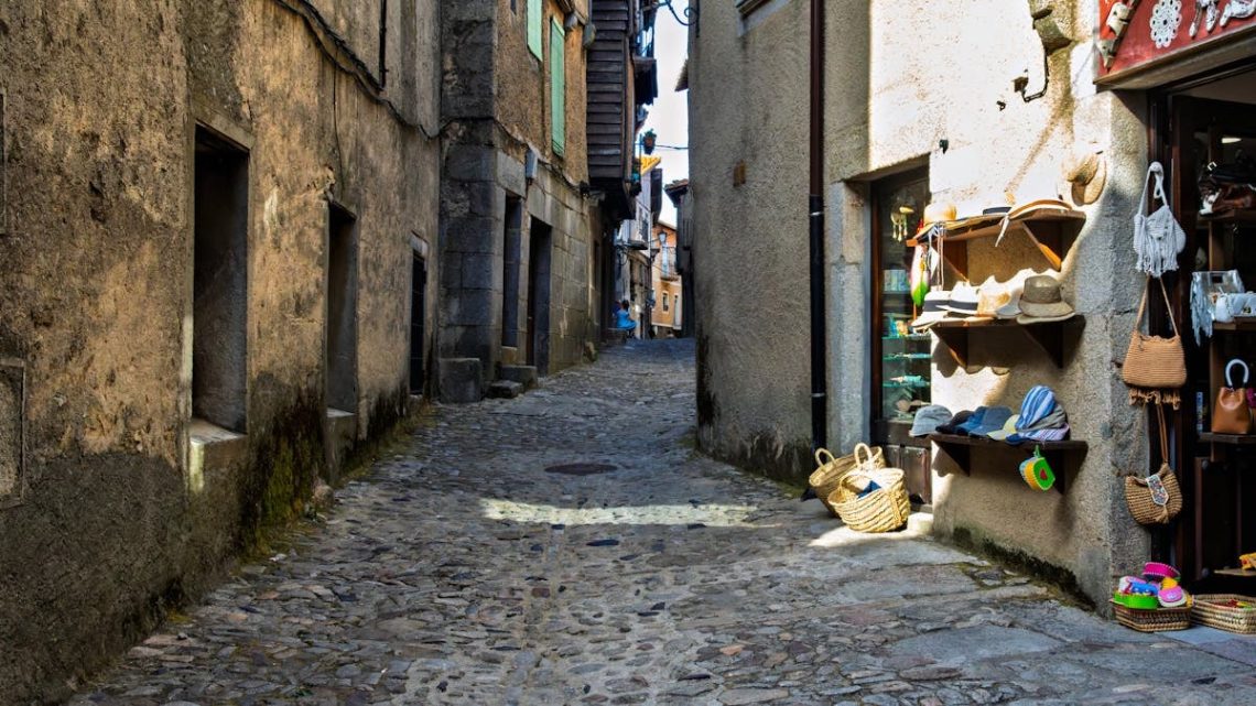 Explore the rustic charm of a cobbled street in La Alberca, Spain, lined with boutique shops and historic architecture.